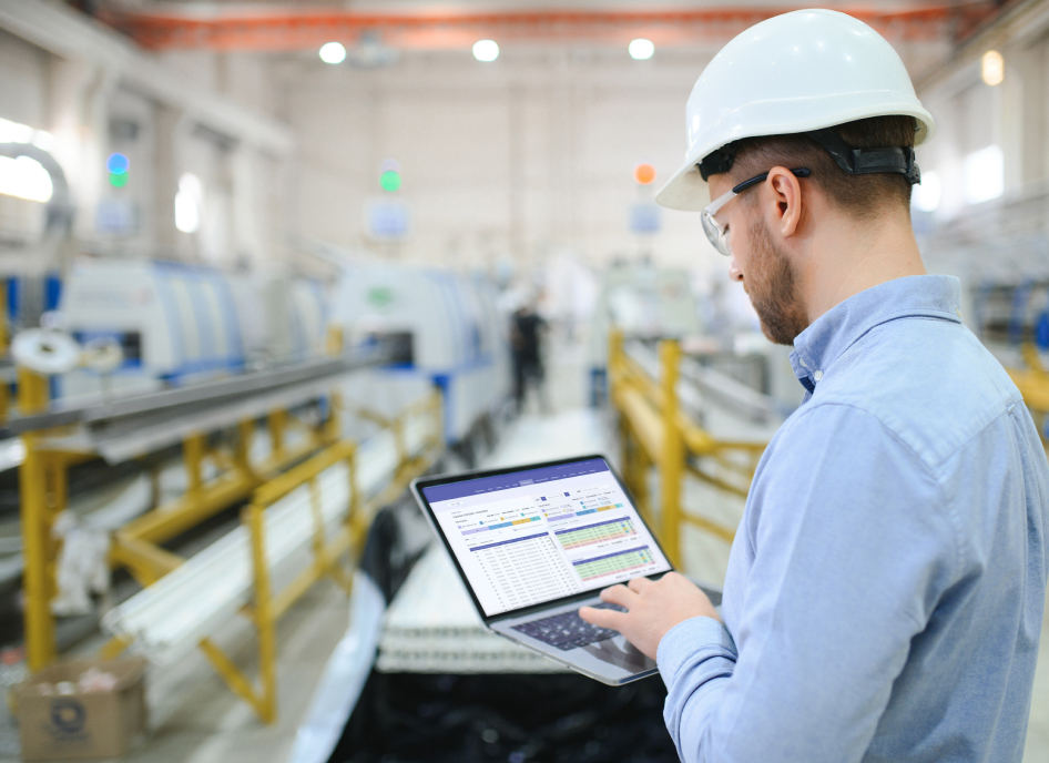 Industrial worker using laptop in warehouse